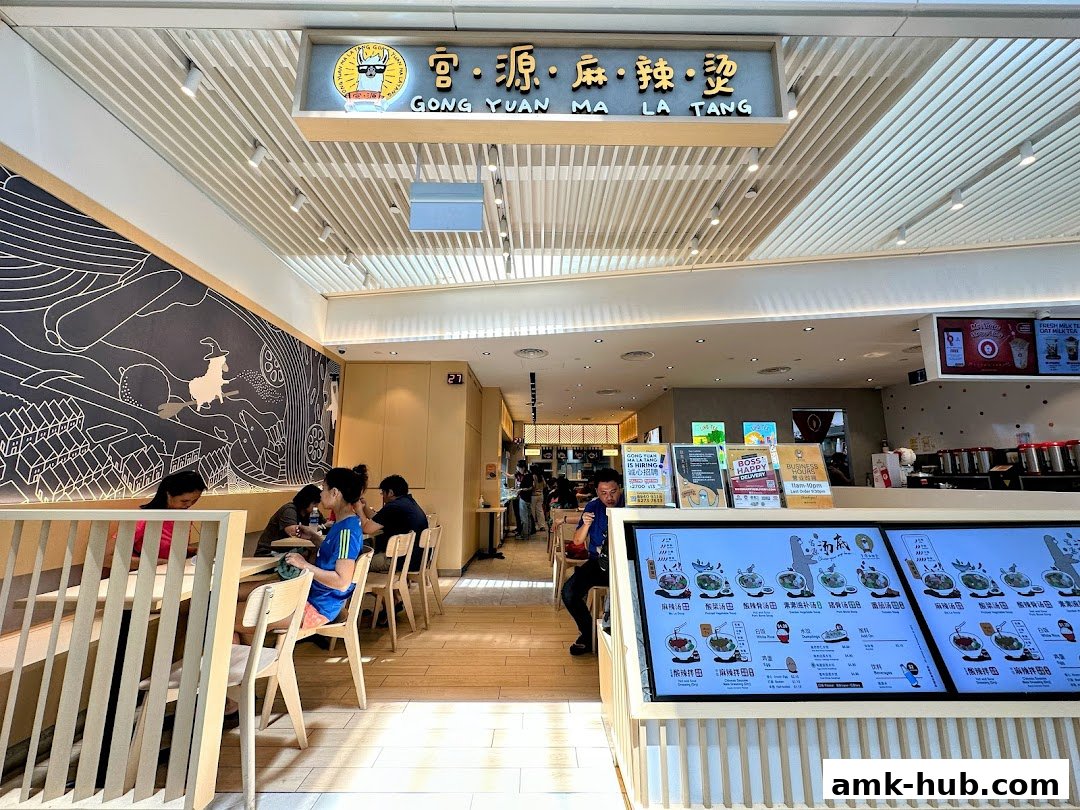 Interior view of Gong Yuan Ma La Tang with customers dining and menu displays.