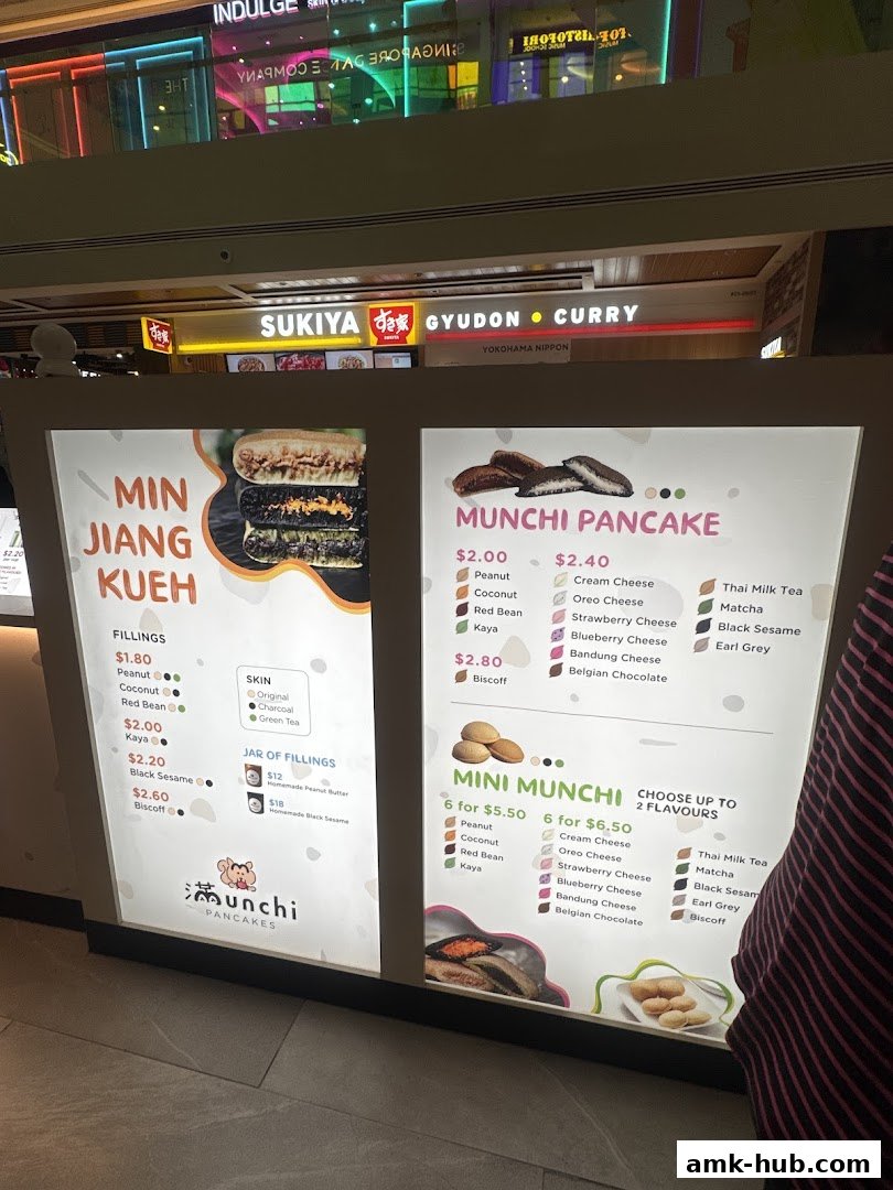 A brightly lit menu board for Munchi Pancakes, showcasing various pancake fillings and flavors.