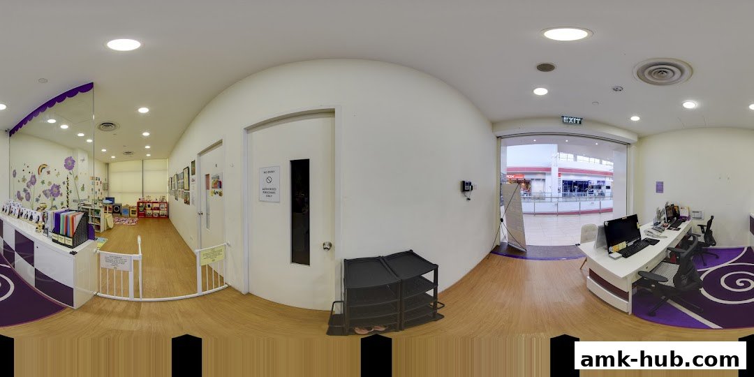 Interior view of a brightly lit children's learning center with a reception desk and play area.