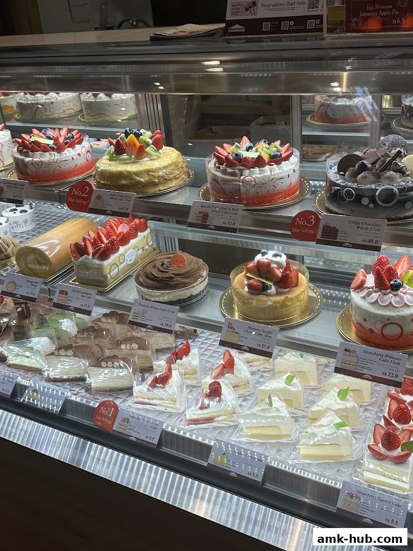 A display case filled with various beautifully decorated cakes and pastries.