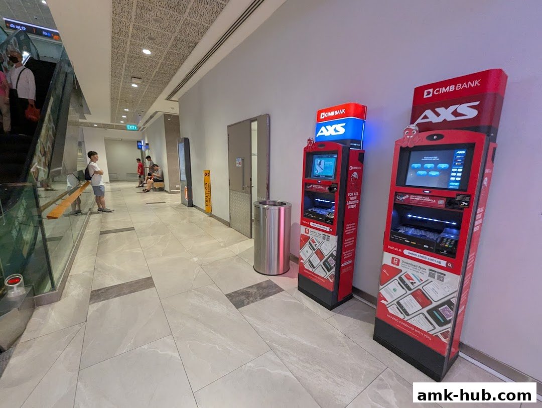 Two red AXS ATMs are shown in a modern shopping mall hallway.