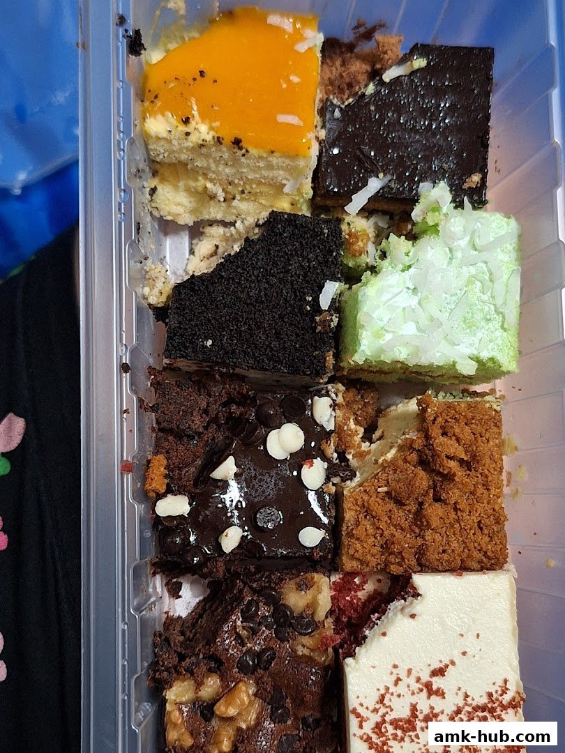 A selection of assorted dessert slices in a clear plastic container.