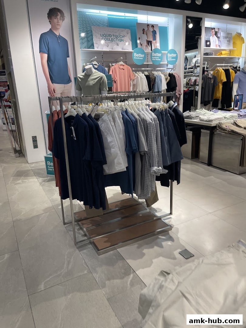 Interior view of a Giordano clothing store showcasing men's polo shirts and casual wear.