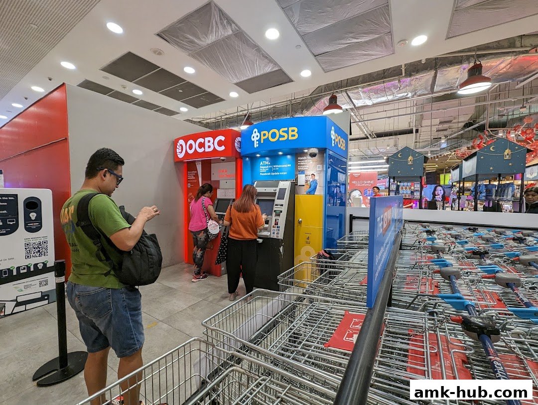 People using OCBC and POSB ATMs inside a Fairprice Xtra supermarket.