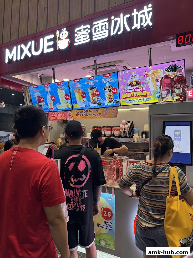 A Mixue ice cream and beverage shop with a menu display and customers queuing.