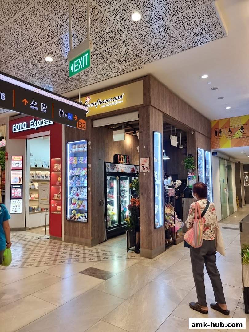 A flower shop with plush toys and balloons displayed in a mall.