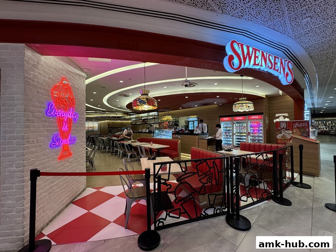 The entrance to Swensen's AMK Hub, featuring a neon ice cream sign and red booth seating.