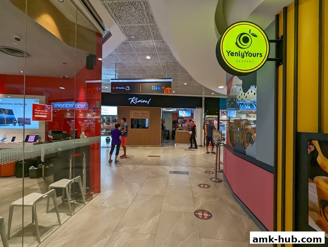A view of a shopping mall corridor with several shop fronts visible, including Revival Hair Gallery.