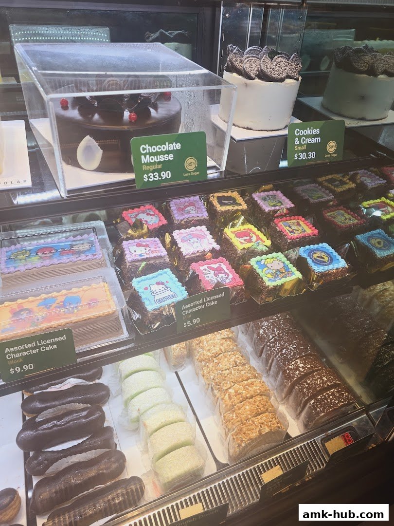 A display case filled with various cakes and pastries, including character cakes and eclairs.