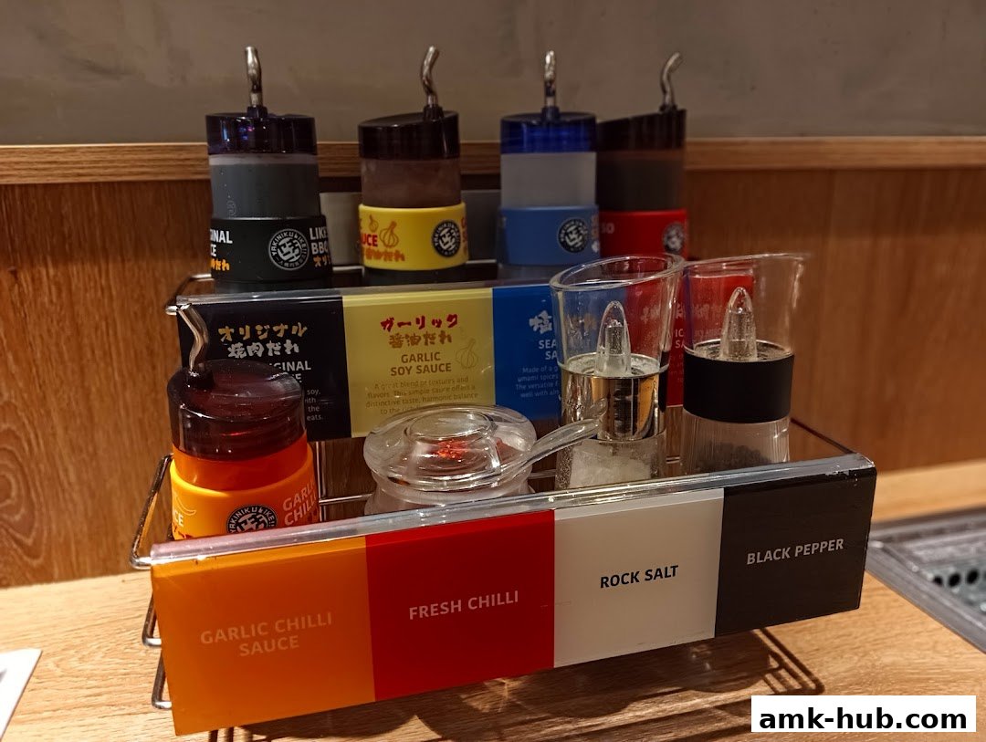A close-up of various sauces and seasonings available at Yakiniku Like.