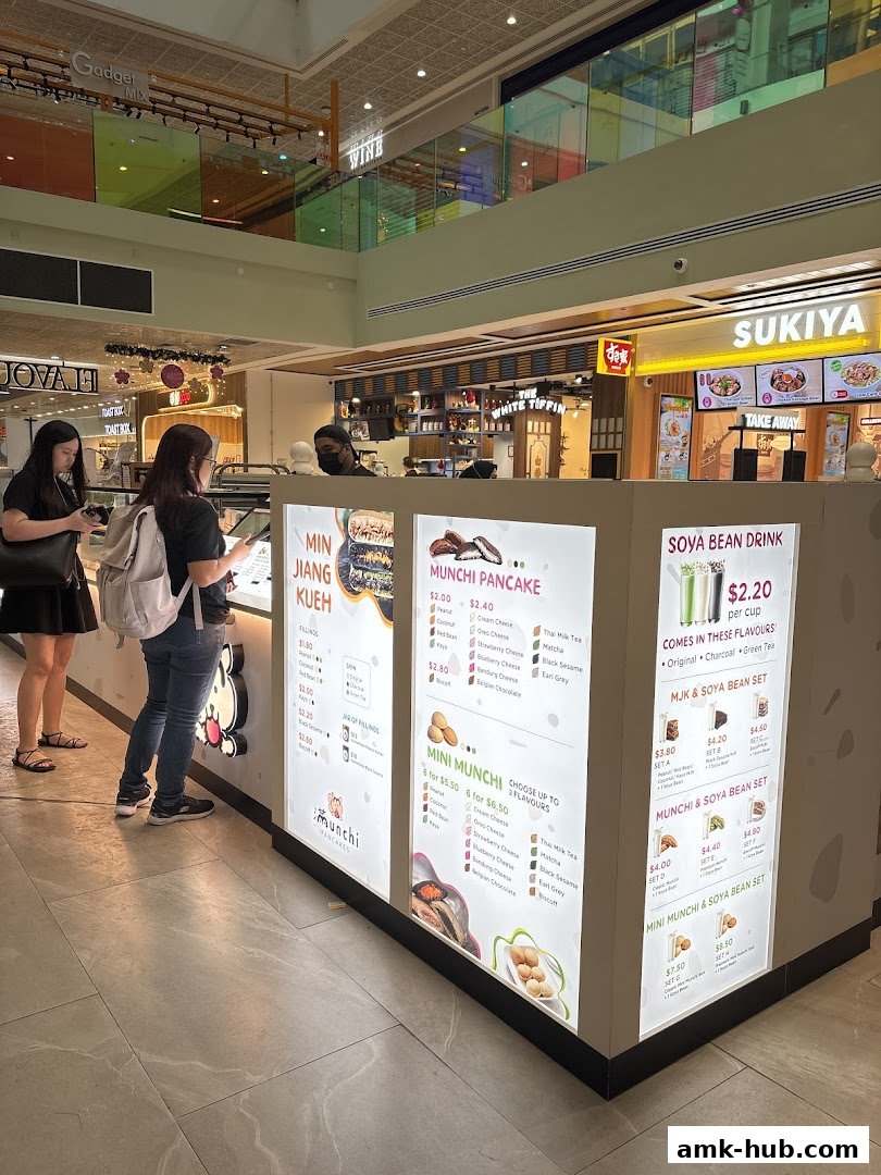 A food stall in a mall with illuminated menus displaying pancakes and drinks.