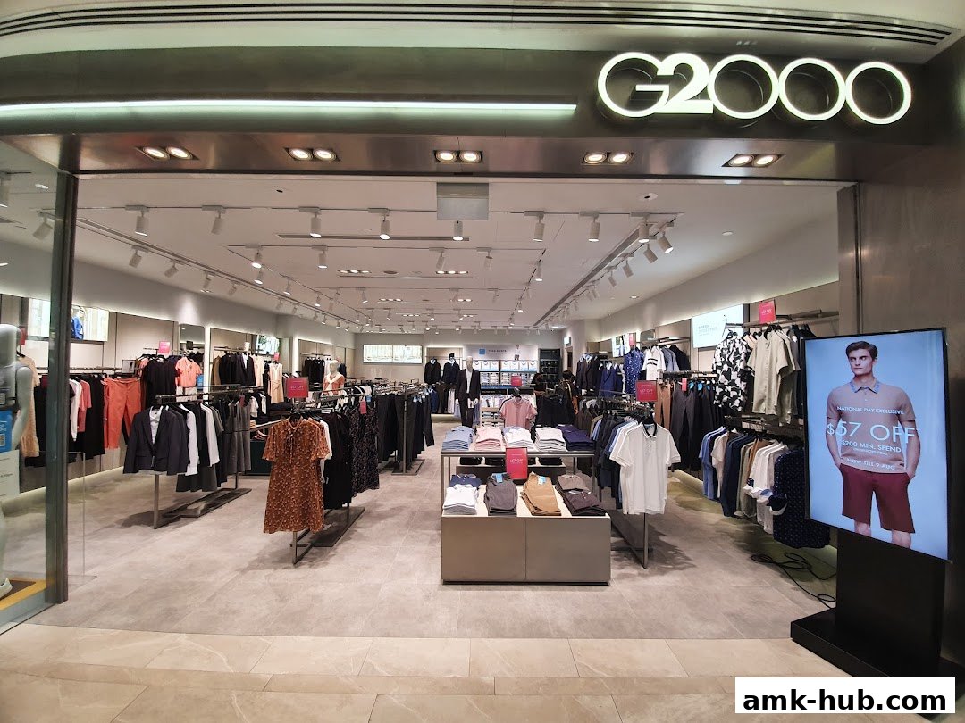 The entrance of a G2000 clothing store showcasing a variety of men's and women's apparel.