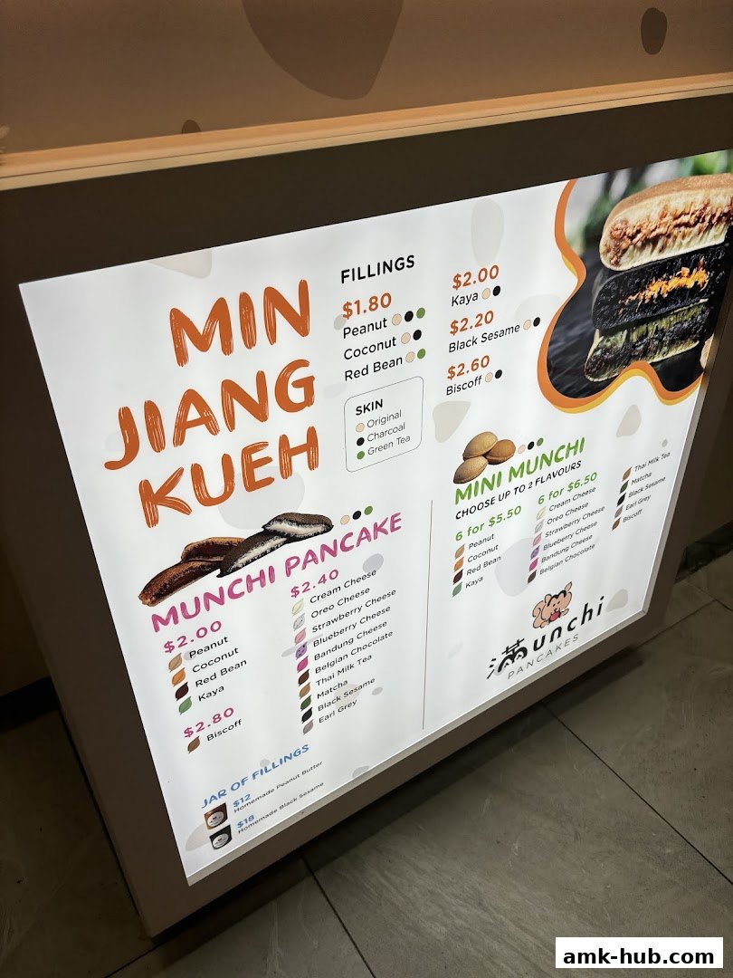 A brightly lit menu board for Munchi Pancakes, showcasing various fillings and pancake options.