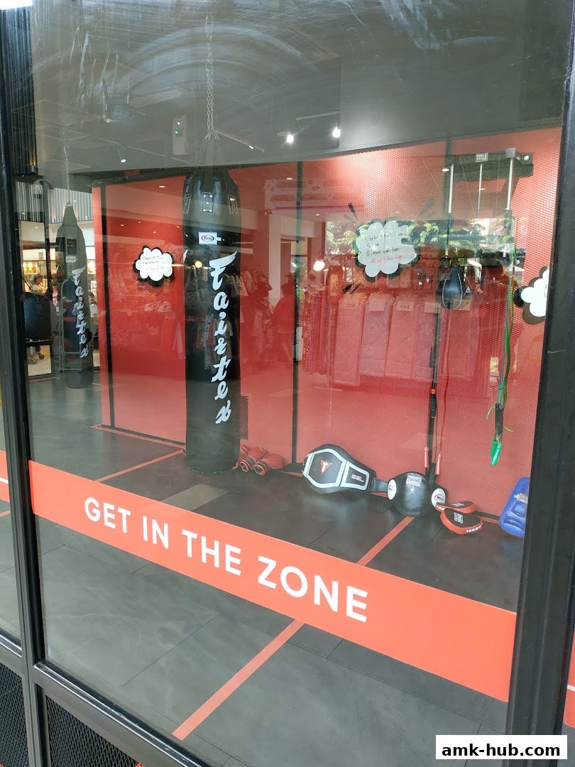 Shop window display featuring boxing equipment like punching bags and gloves, with a 'Get in the Zone' slogan.