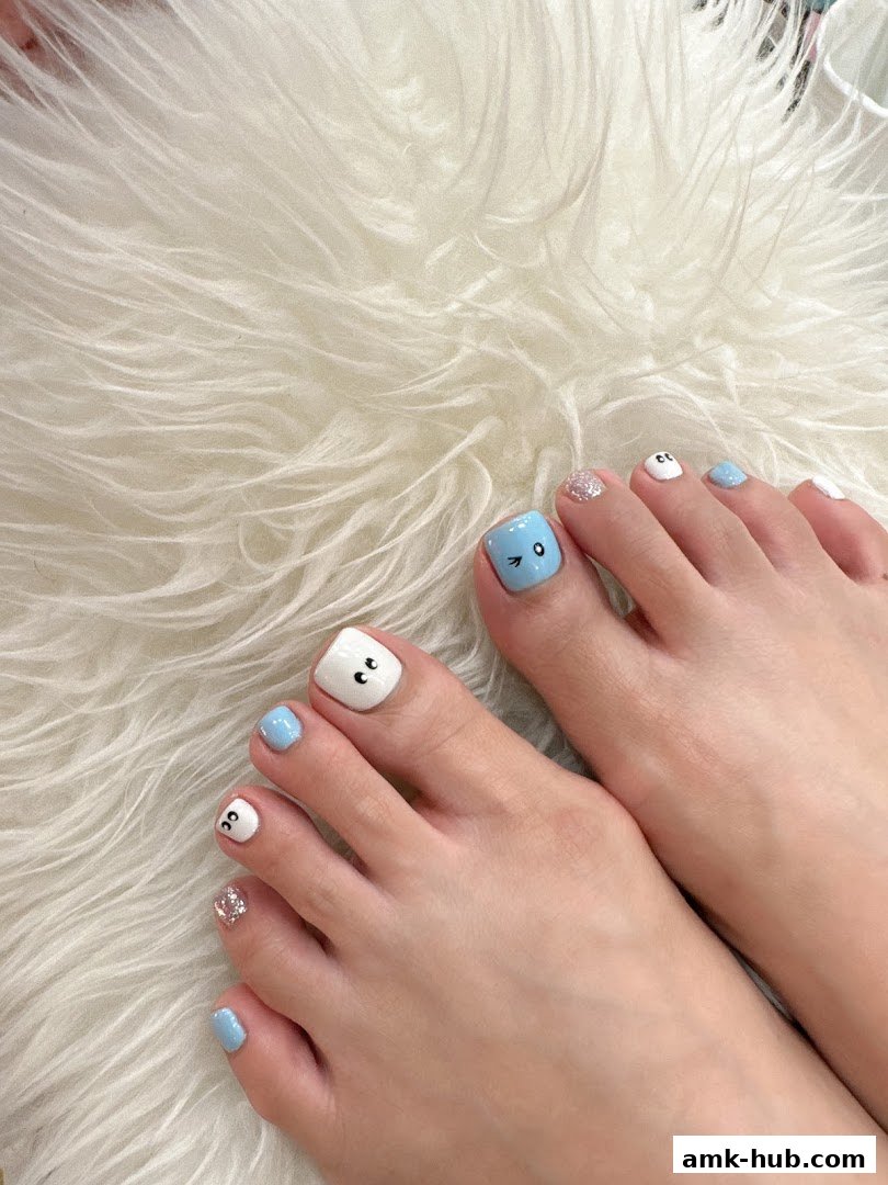 Close-up of feet with cute cartoon-themed nail art on toes.
