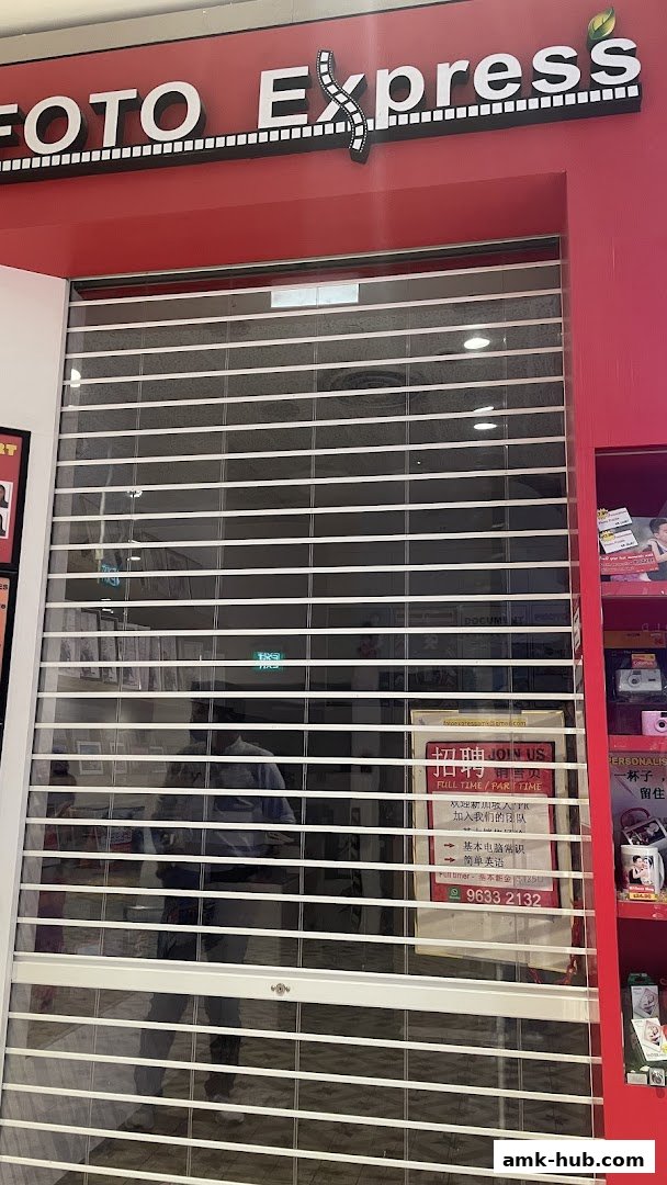 The storefront of Foto Express, a photography shop, with its roller shutter down.