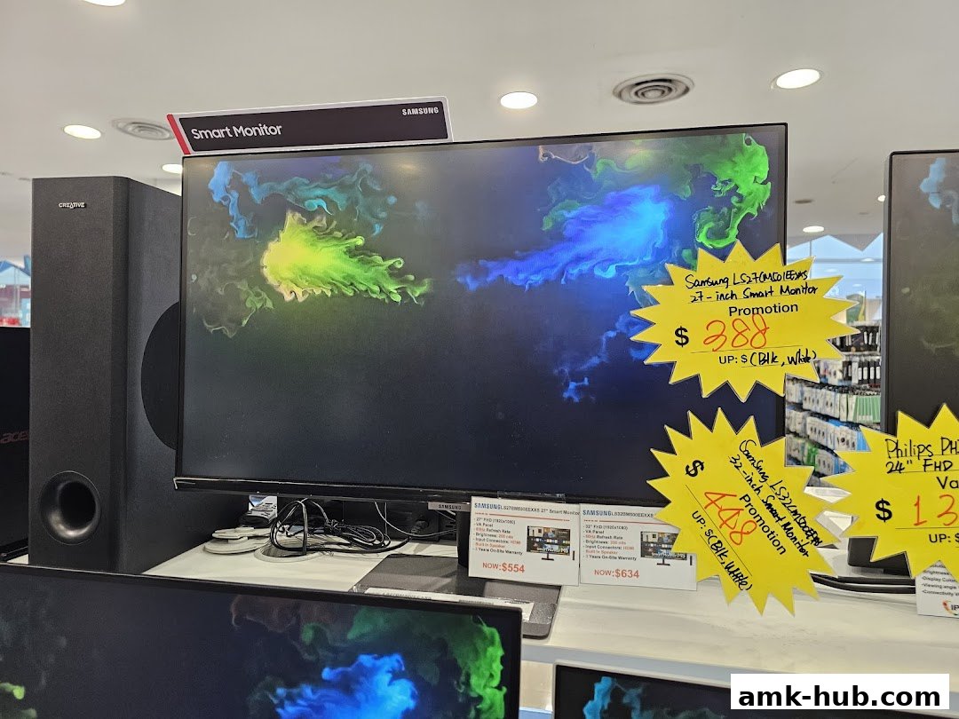 A display of Samsung smart monitors and a Creative speaker in a retail store.