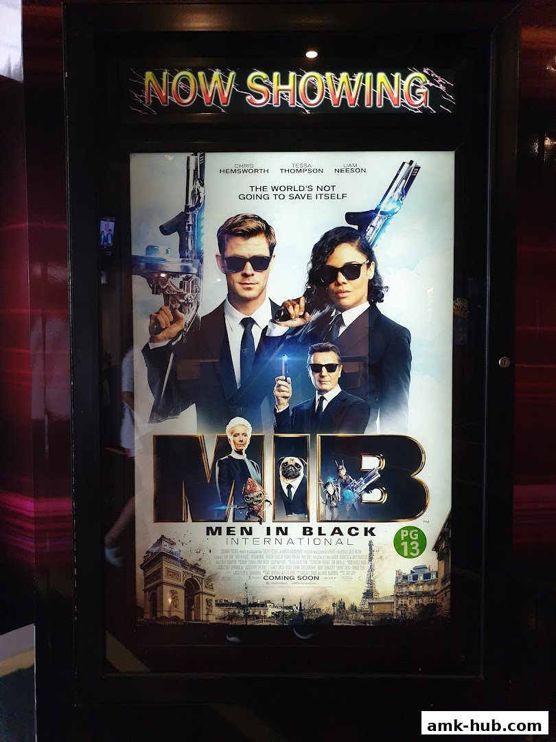 A movie poster for Men in Black: International is displayed, advertising it as 'Now Showing'.