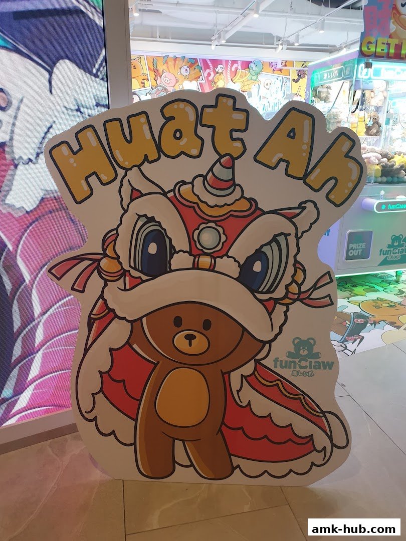A cutout of a cartoon bear in a lion dance costume with 'Huat Ah' text.