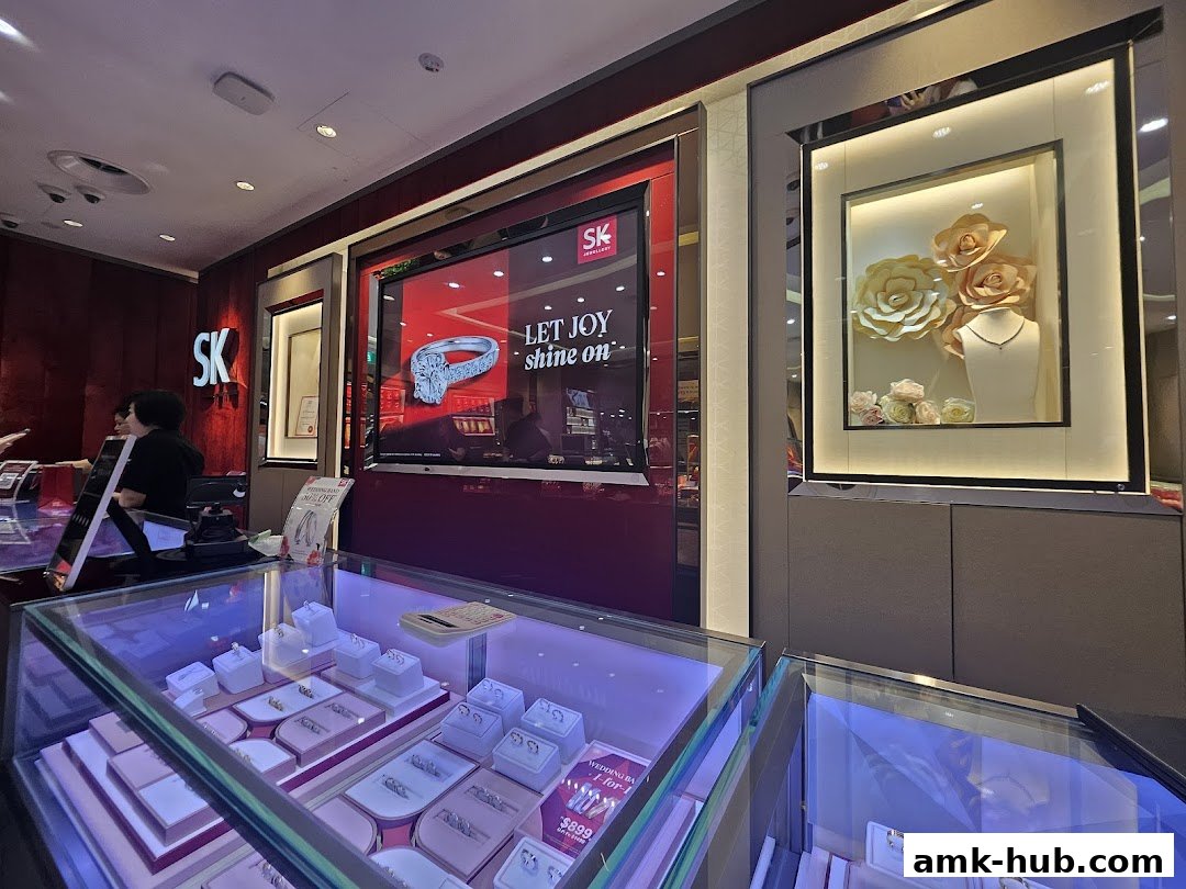Interior view of SK Jewellery store showcasing display cases with rings and a promotional screen.