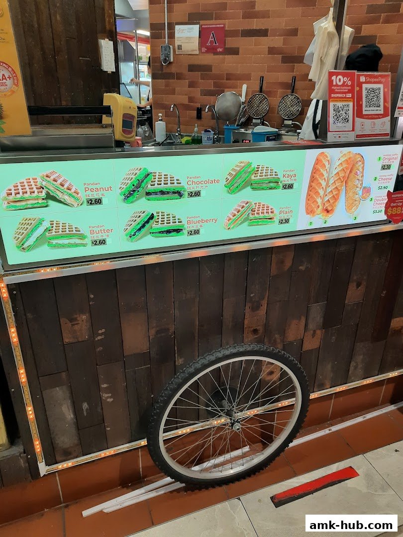 A display of various pandan waffles with different fillings and prices.