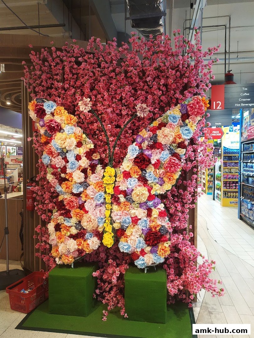 A large butterfly made of colorful flowers and pink cherry blossoms.