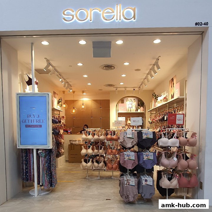 The entrance of a Sorella lingerie shop displaying bras and underwear, with a promotional sign.