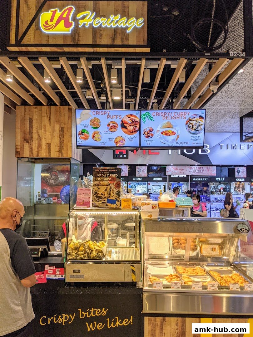 A food stall named 1A Heritage with a display of crispy snacks and a menu board.
