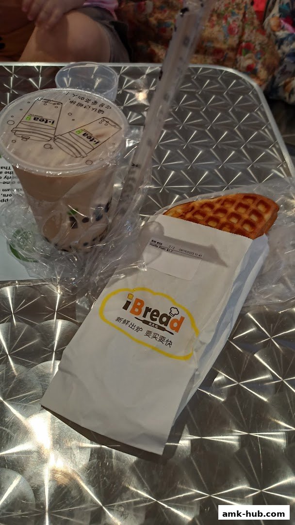 A bubble tea from iTea and a waffle from iBread are displayed on a metallic surface.