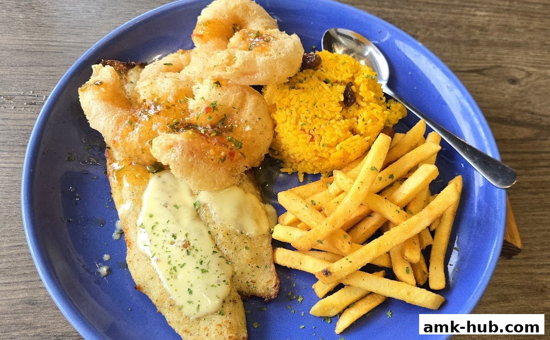 A blue plate holds a seafood dish with fish, fries, rice, and fried calamari.