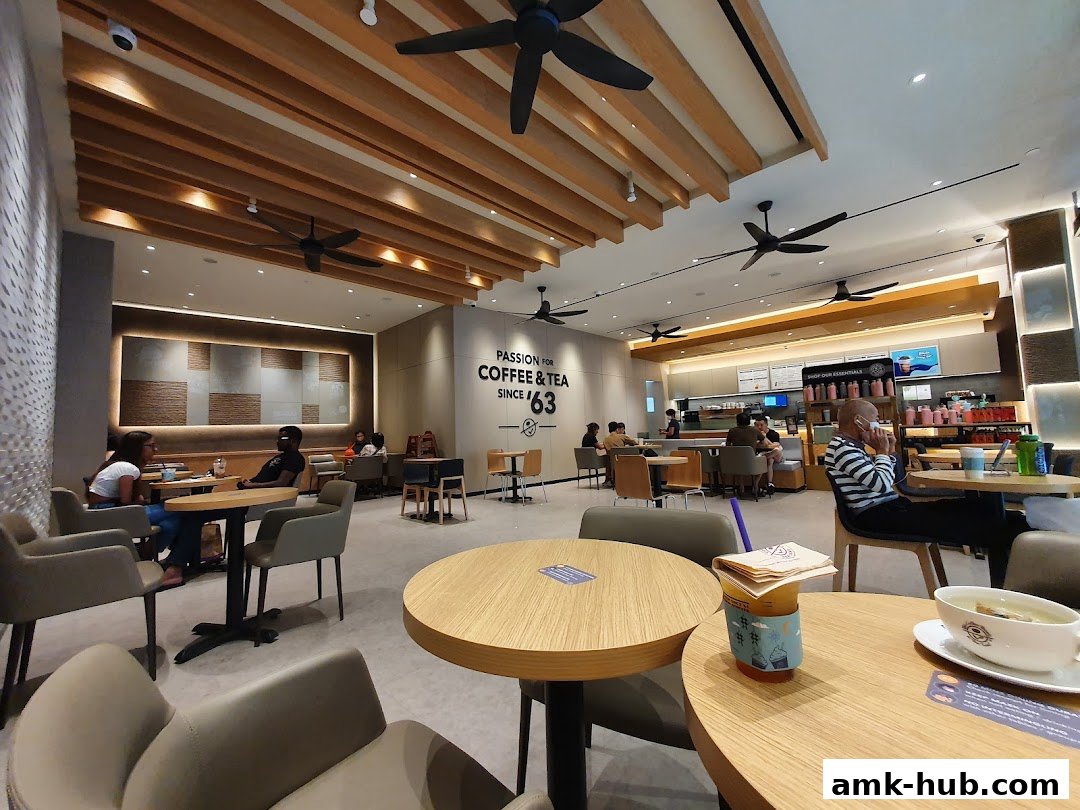Interior of a Coffee Bean and Tea Leaf cafe with customers seated at tables.