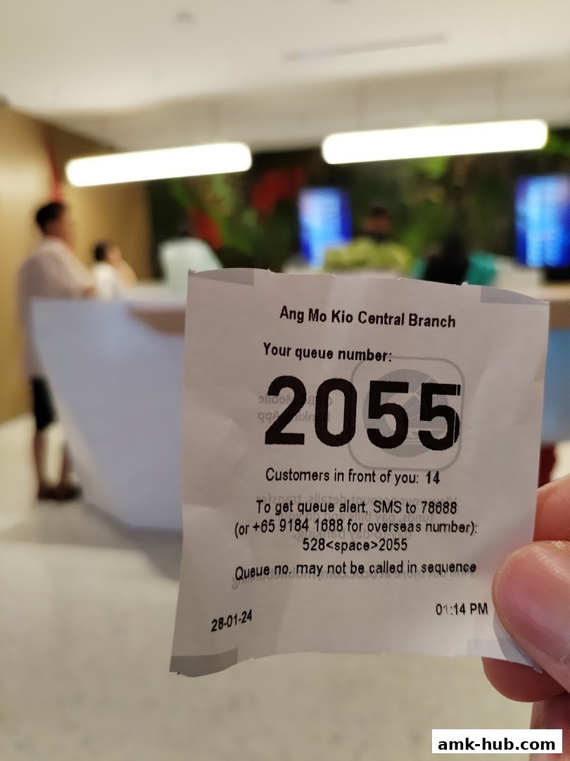 A queue ticket from OCBC Bank Ang Mo Kio Central Branch showing queue number 2055.