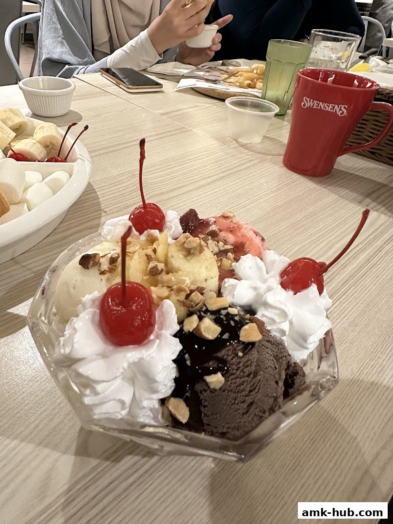 A delicious ice cream sundae with cherries, whipped cream, and nuts, served at Swensen's.