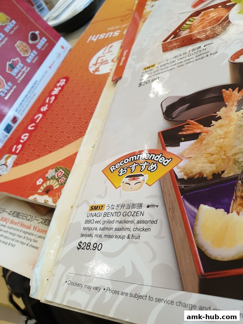 A close-up view of a Japanese restaurant menu featuring bento boxes and sushi.