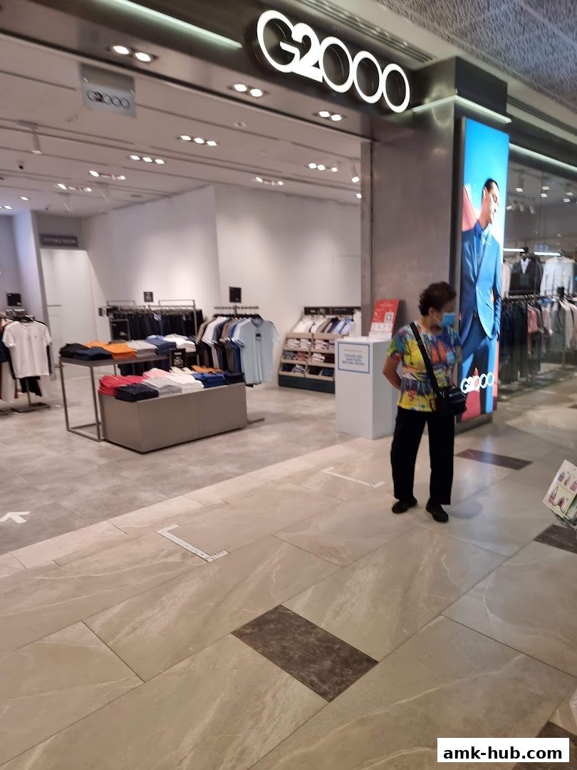The G2000 shop entrance with clothing displays and a customer.