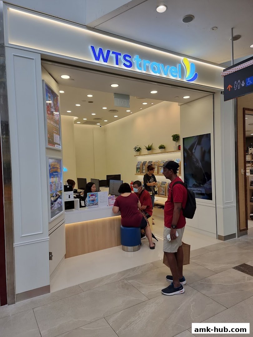 WTS Travel shop front with staff and customers interacting at the counter.