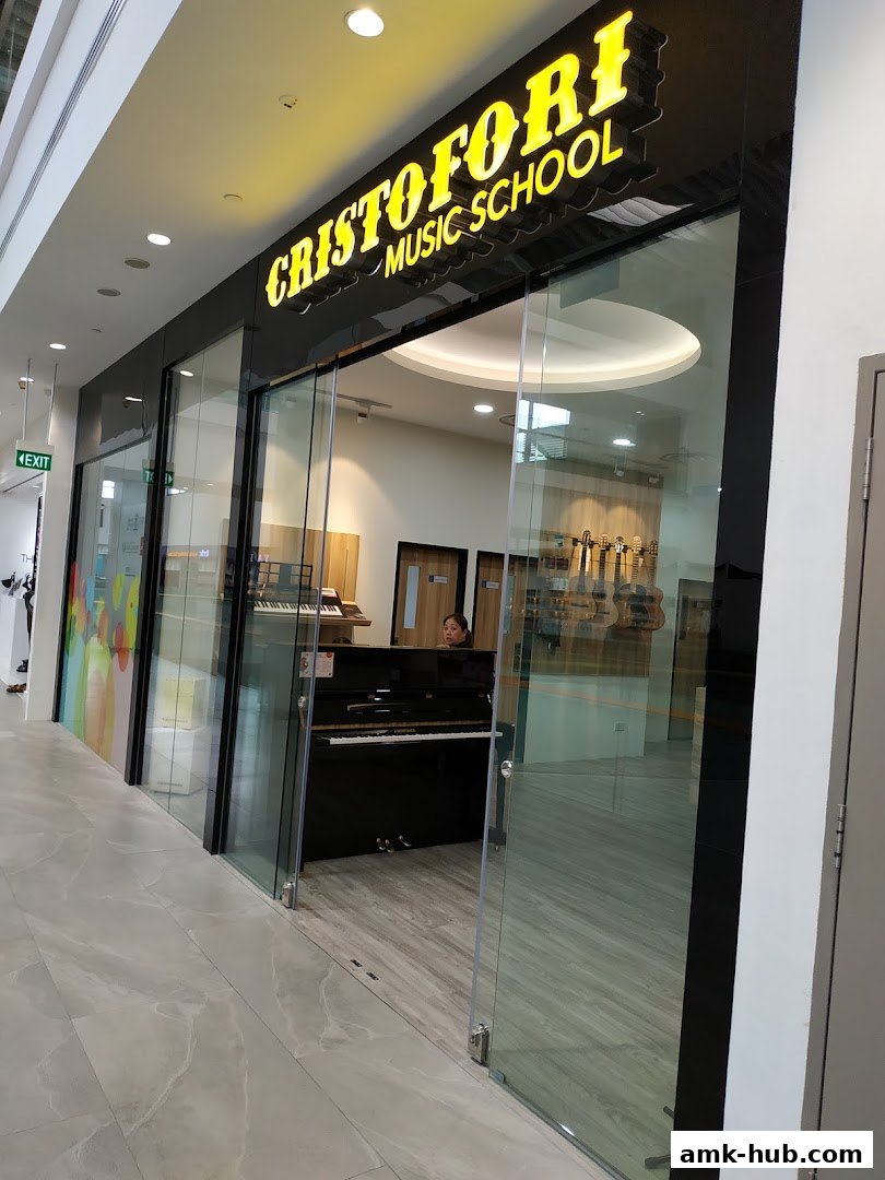 The entrance to Cristofori Music School, featuring a piano and musical instruments displayed inside.