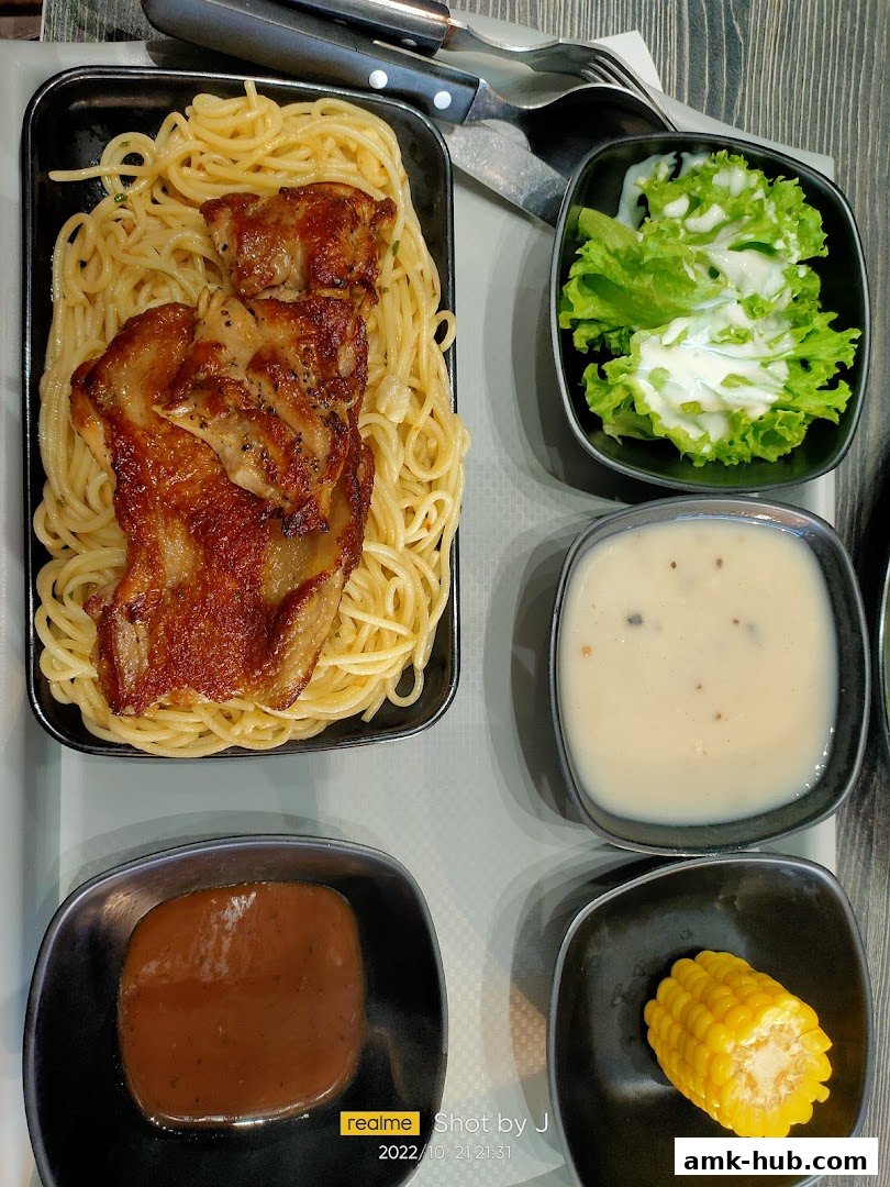 A delicious meal featuring grilled chicken, spaghetti, salad, corn, and sauce.