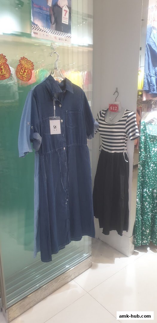 A display of women's dresses, including a denim shirt dress and a striped top with a black skirt.