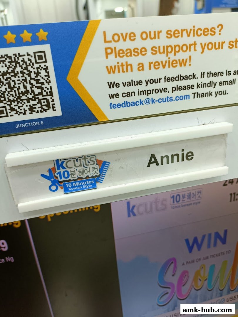A sign at kcuts hair salon with a QR code and a staff name tag.