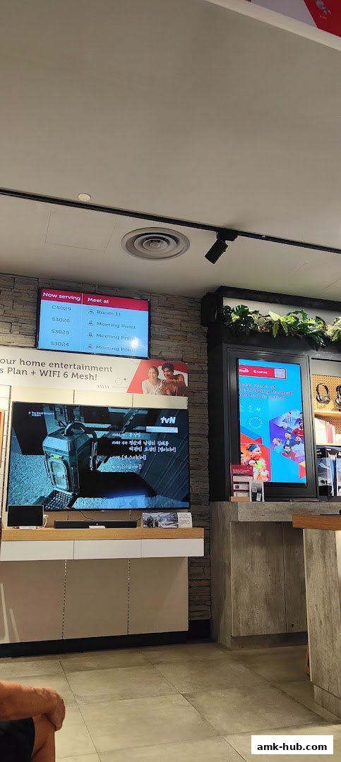A digital display shows a queue number and meeting points, with a TV screen displaying content.