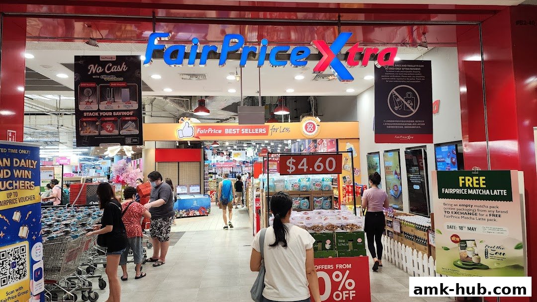 The entrance of a FairPrice Xtra supermarket with promotional displays and shoppers.