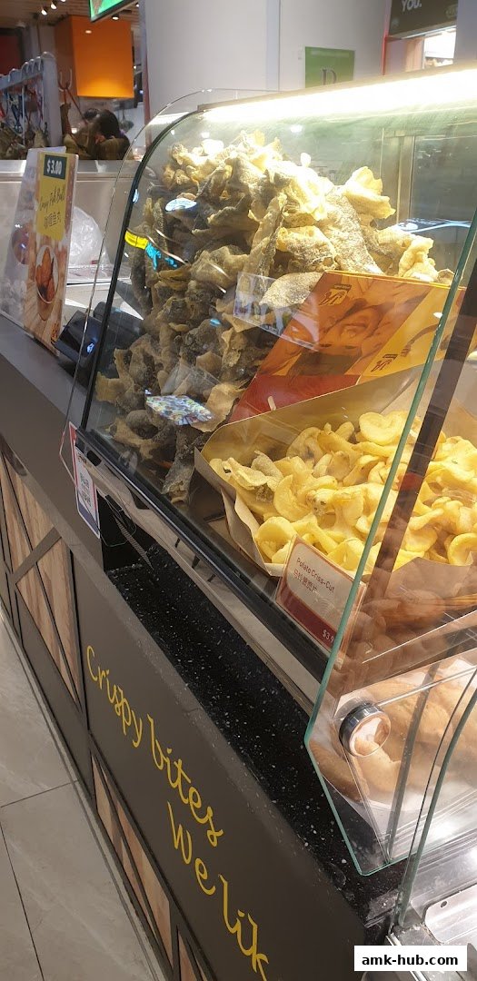 A display case filled with crispy snacks, including fish skin and potato crisps.