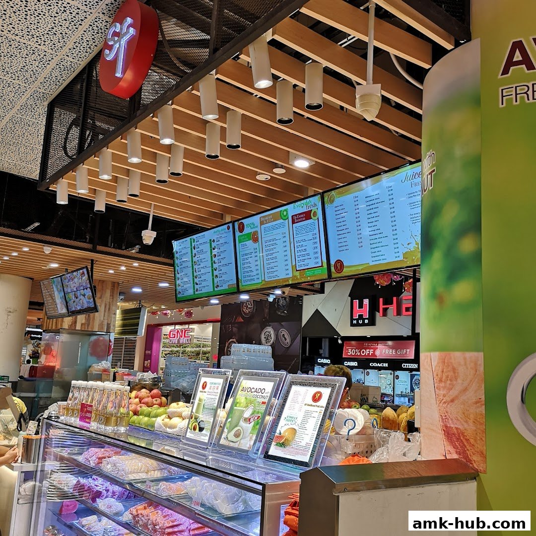 A brightly lit juice bar with digital menus displaying various fruit juices and drinks.