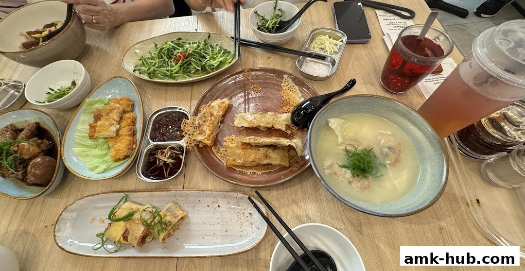 A table laden with various Chinese dishes, including dumplings, soup, and braised meat.