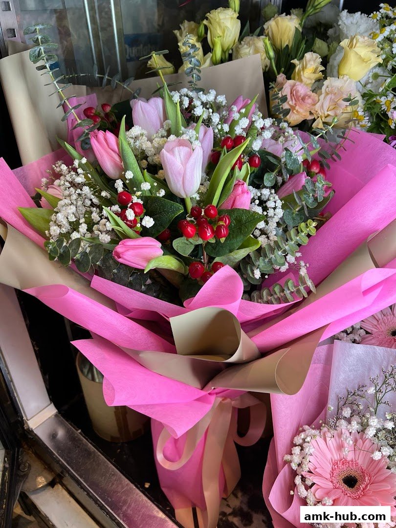 Beautifully arranged bouquets of pink tulips and other flowers with decorative wrapping.