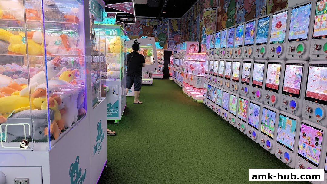 Interior of a brightly lit arcade with rows of claw machines filled with plush toys.
