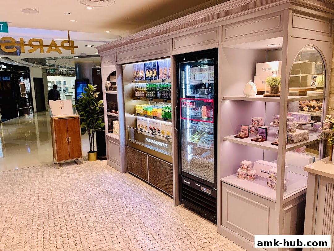 Paris Baguette shop interior with display shelves, refrigerated drinks, and packaged goods.