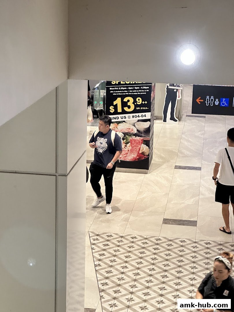 A man walks past a promotional poster for a restaurant special.