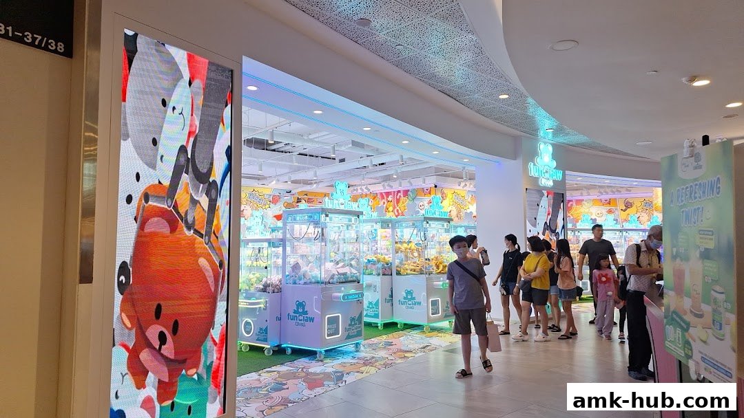 A brightly lit arcade shop with multiple claw machines filled with plush toys.